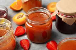 Composition with jam and ingredients on gray background, close up