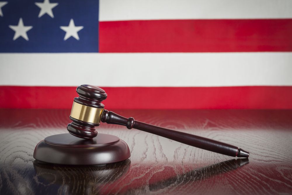 Wooden Gavel Resting on Flag Reflecting Table