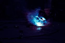 Professional welder in mask welding metal