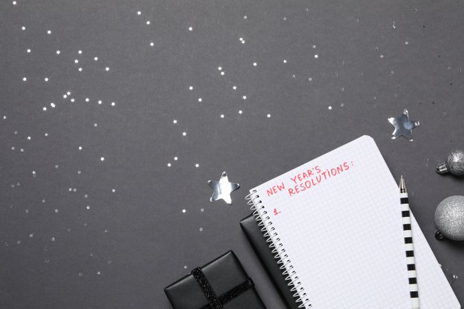 Gift boxes and notepad with list on gray background, space for text