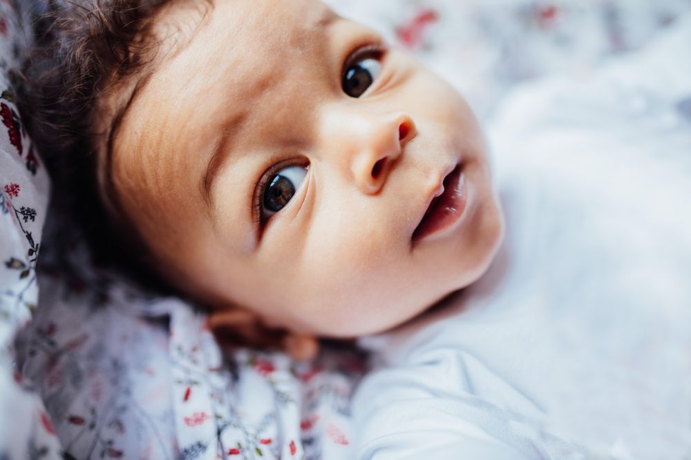 Portrait of baby boy with huge eyes and curly hair