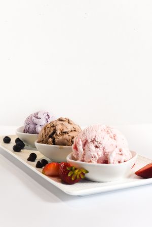 Plate of three different flavored ice cream scoops, vertical