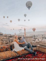 Man and woman looking at hot air balloon in sky 4mkmd0