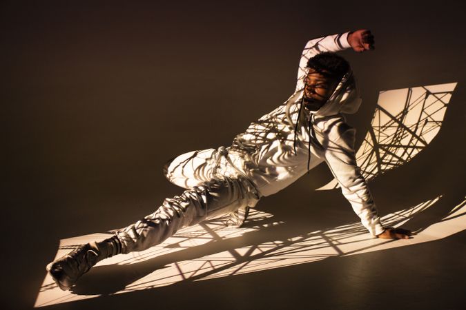 Black man dancing under bright light