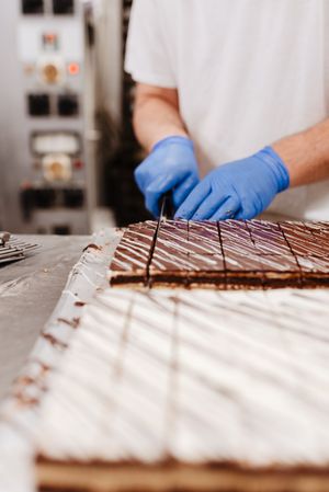 Anonymous cook cutting cake on table