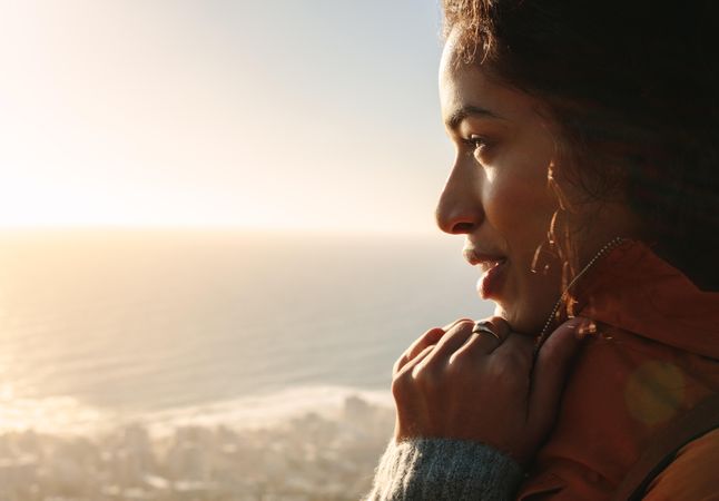 Female admiring the beautiful view of sea with bright sunshine