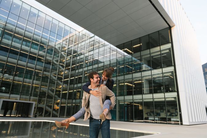 Cheerful couple having fun and hugging on street in downtown