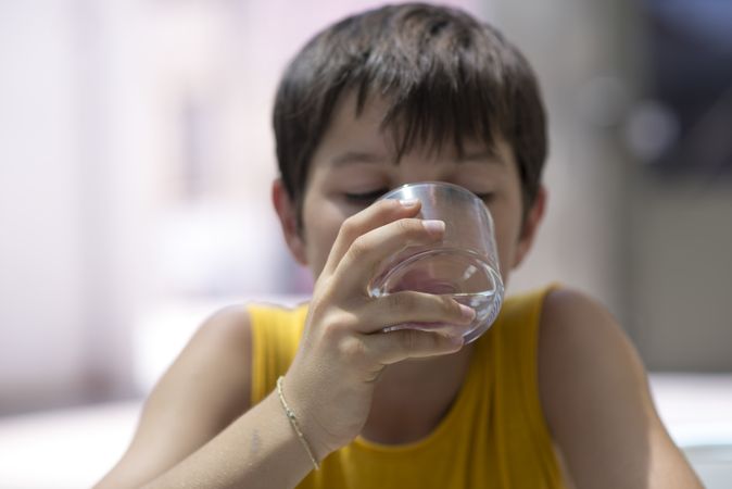Child drinking a glass of pure water