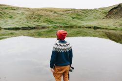 Man in field looking over the water