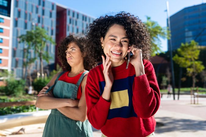 Female speaking on phone while friend feels left out