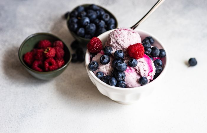 Bowls of summer dessert with ice cream and berries