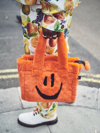 London, England, United Kingdom - September 18 2021: Person holding fluffy orange handbag
