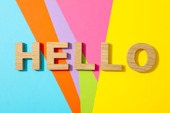Word Hello lined with wooden letters on multicolor background