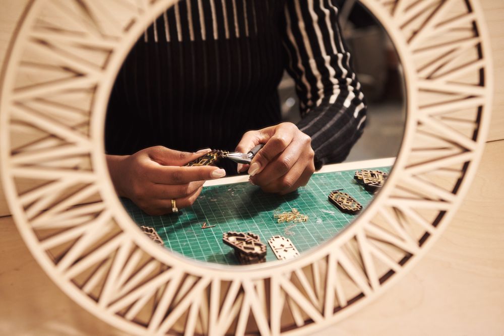 Reflection in the mirror of woman working at cutting board