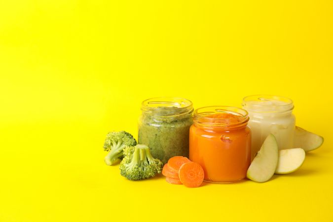 Composition with vegetable puree on yellow background. Baby food