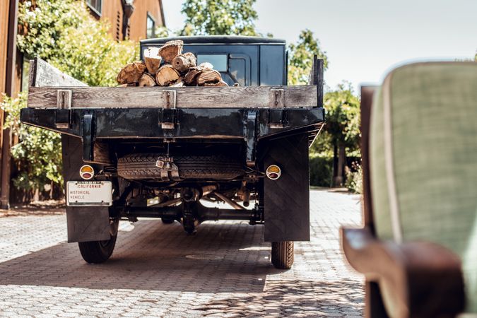 Retro truck with logs parked near building