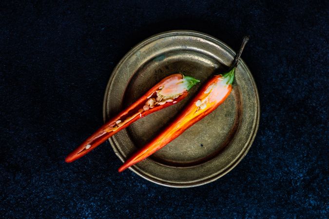 Split red hot chili pepper on dark background with copy space
