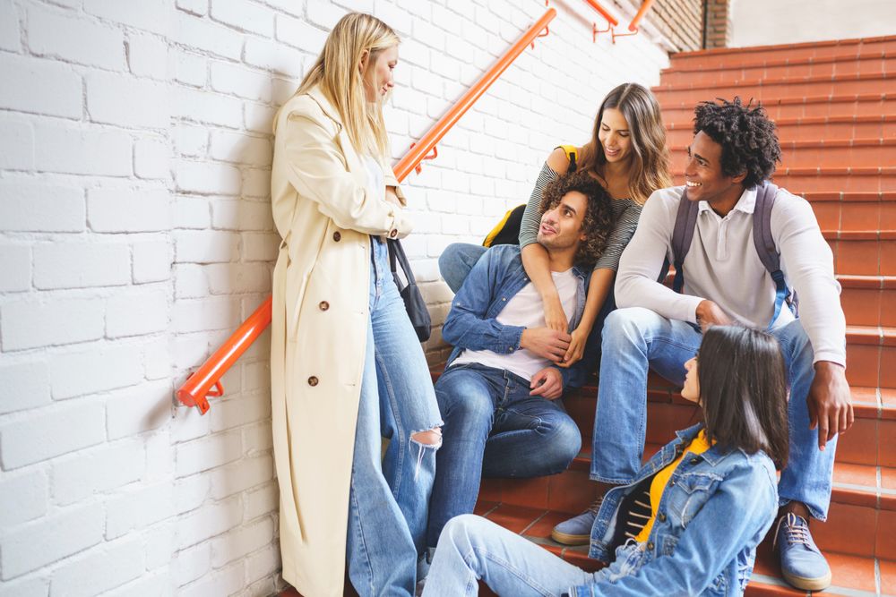 Happy friends hanging out with each other on brick steps