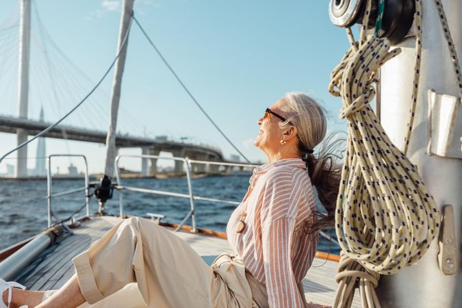 Stylish mature woman relaxing on a yacht bow