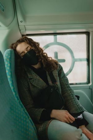 Woman with facemask sleeping in bus