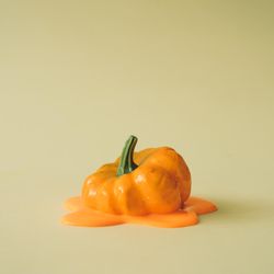 Melting pumpkin on beige background