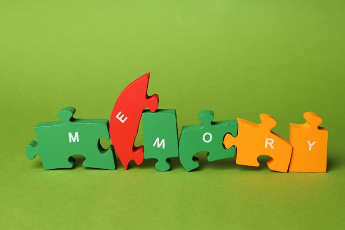 Puzzle pieces spelling “memory” on green background