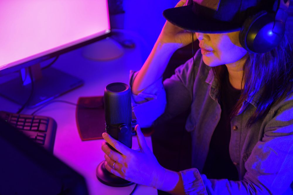 Woman with microphone and headphone working on a computer