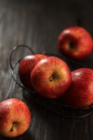 Red Apple on Wire Basket above Rustic Table