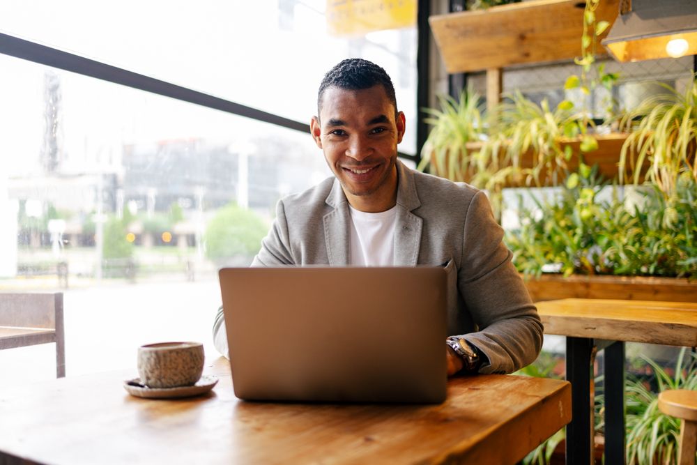 Man working on laptop at cafeteria