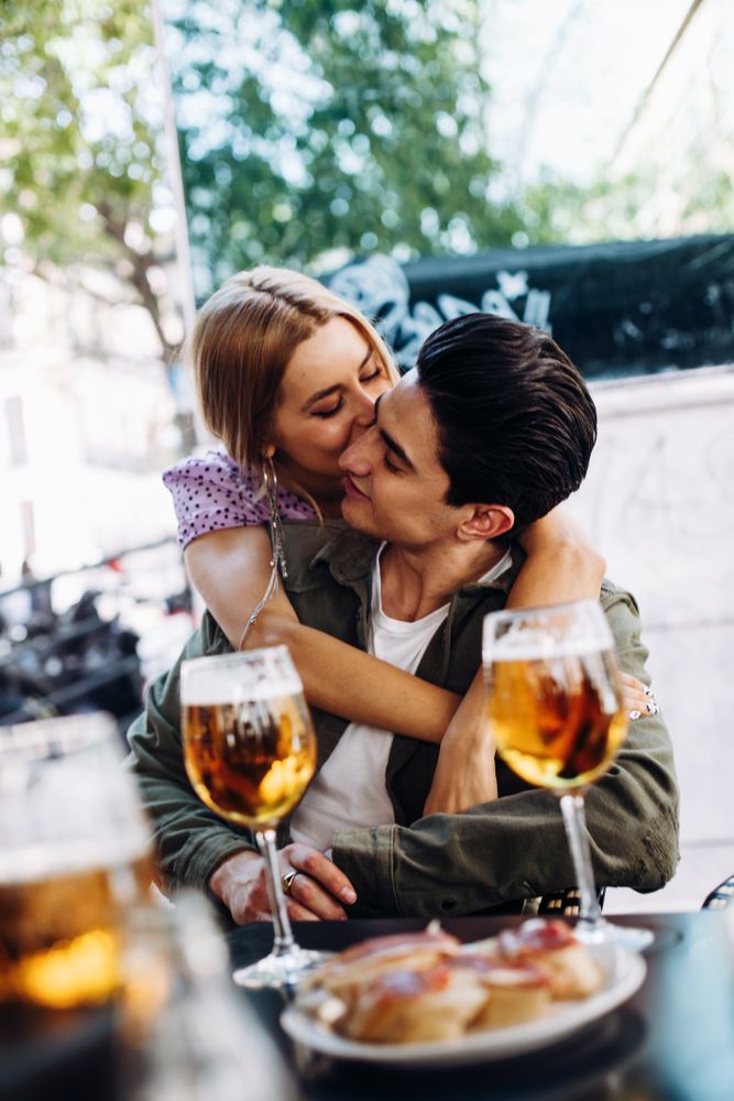 Happy young couple drinking beverages outdoors