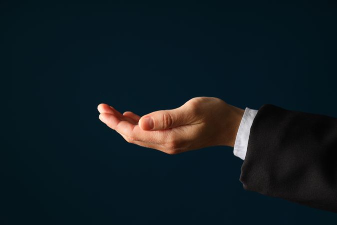 Businessman's hand close-up on a dark background