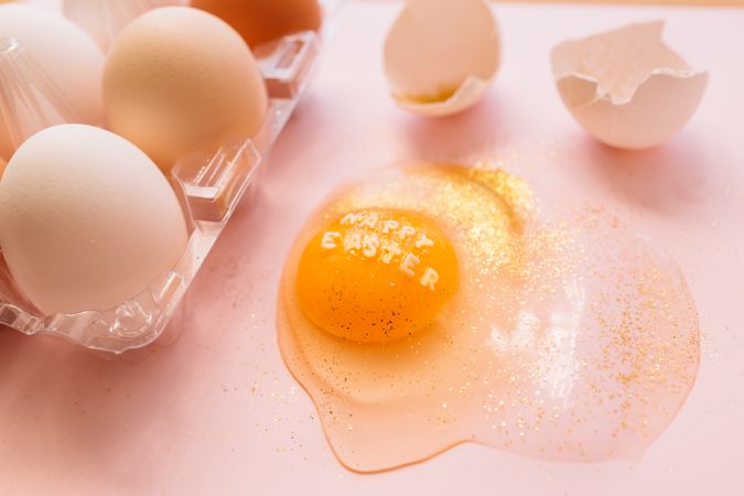 Easter eggs in box and broken egg on table