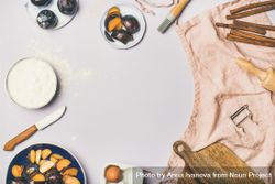 Baking ingredients and tools, plums, pastry brush, cinnamon, eggs on pastel background, copy space 0P6X24