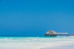 Tropical pier above a clear beach