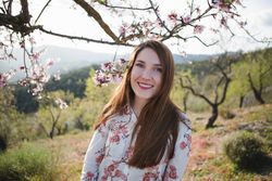 Young happy woman between trees in garden