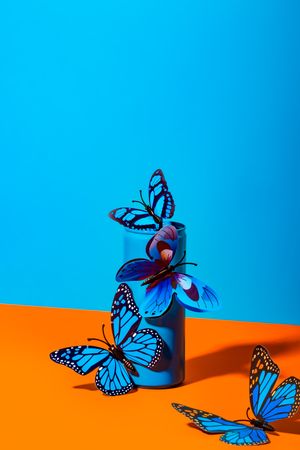 Plastic butterflies on metal blue can