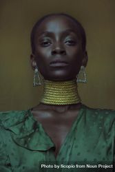 Portrait of Black woman in golden choker necklace and green top bEXwl4