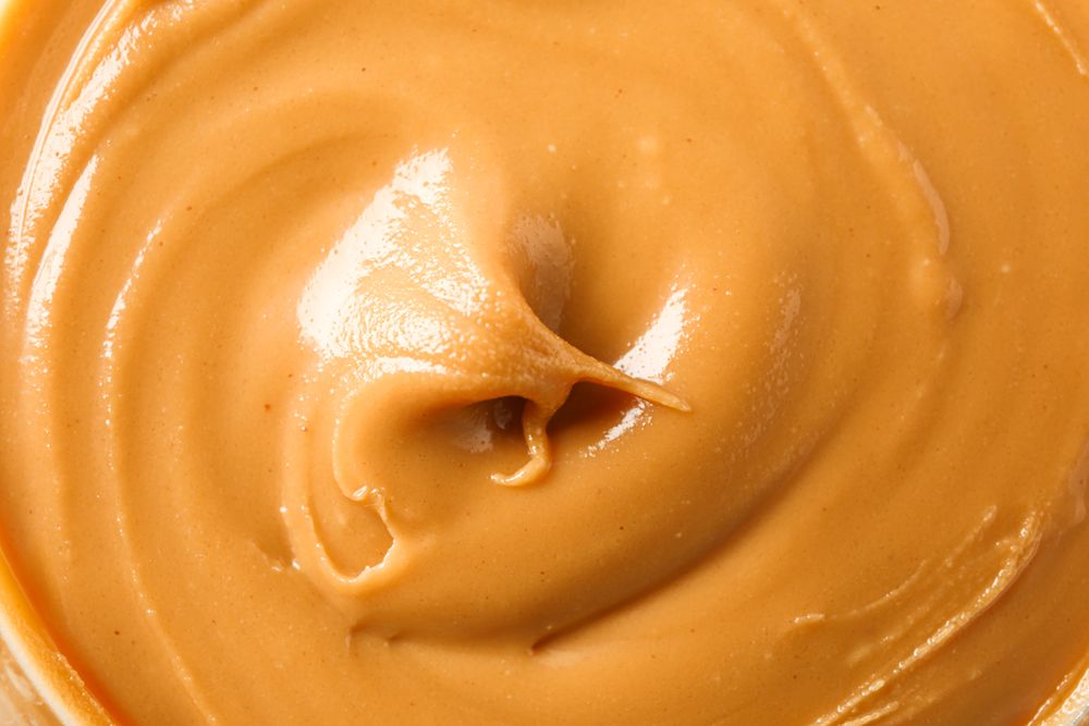 Peanut butter as background, space for text and closeup. A traditional product of American cuisine