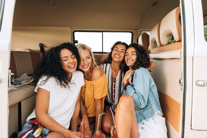 Four women having fun together in a van