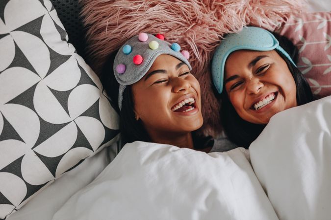 Friends wearing sleeping masks on heads having fun during a slumber party