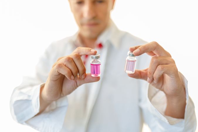 Man in white lab coat studying sample