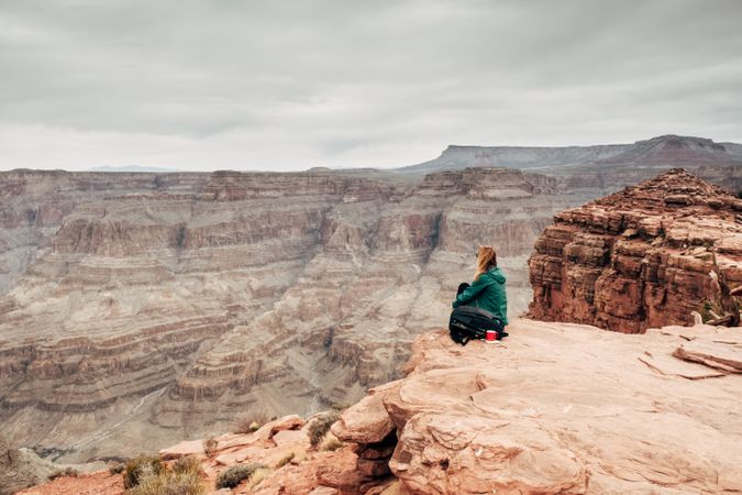 Female relaxing on cliff and admiring picturesque view