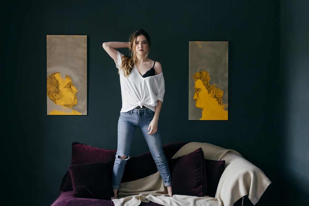 Young female standing on couch in stylish room