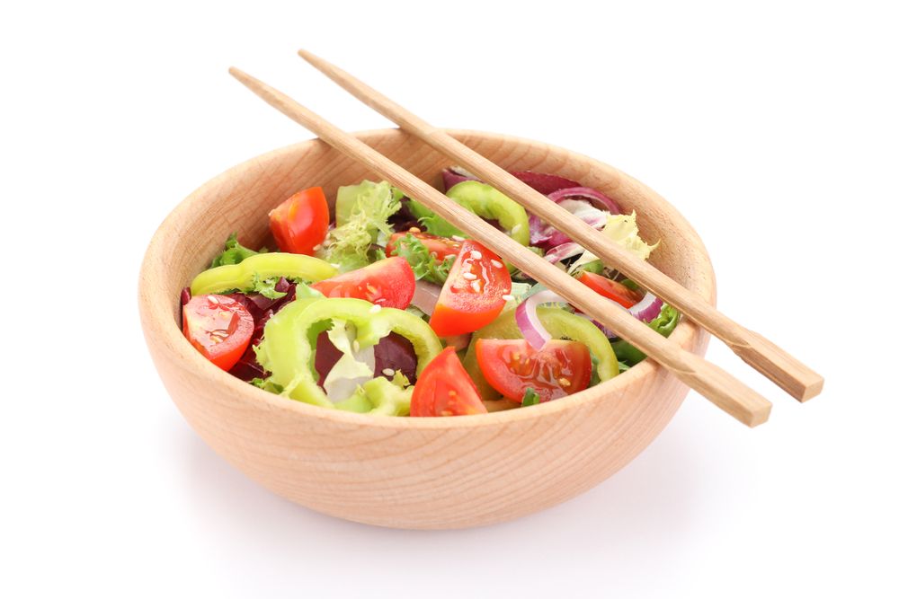 Fresh salad and chopsticks isolated on blank background