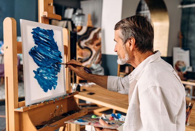 Man with blue paint at easel