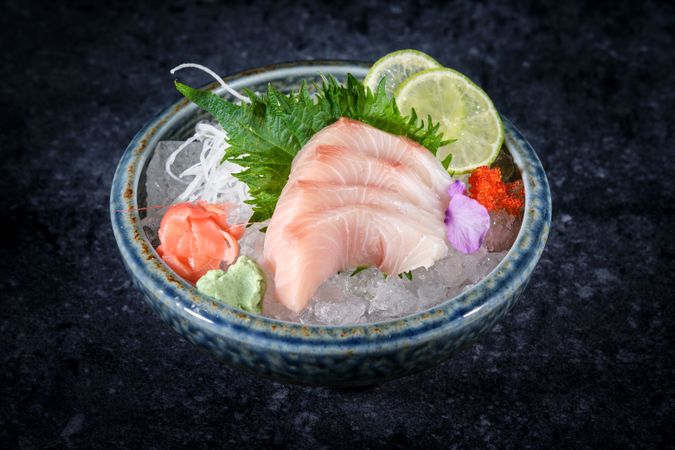 Bowl of sashimi on dark backdrop