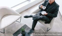 Top view of businessman sitting in office lounge having coffee 0PEN25