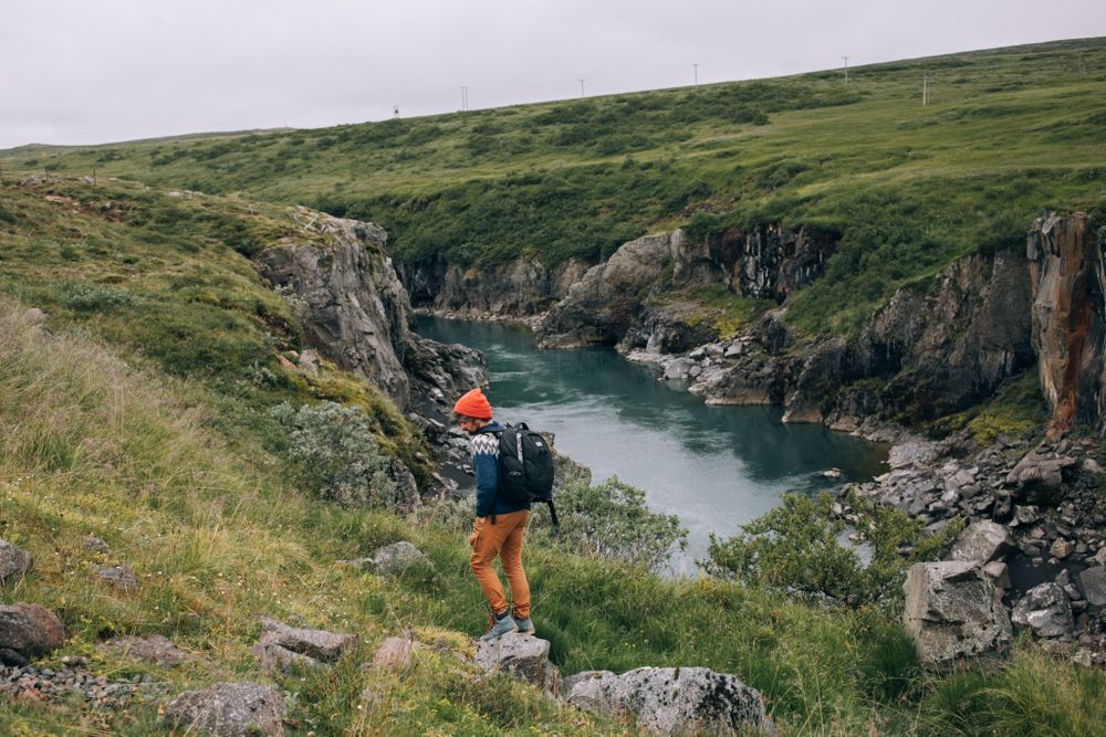 Man hiking along green mountains