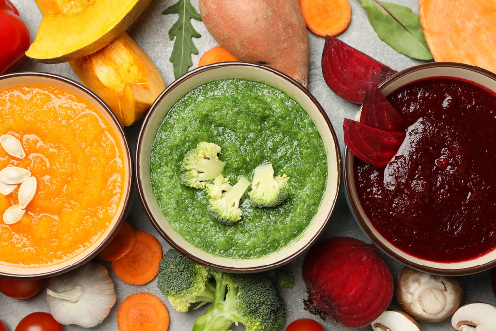 Close up of three colorful soups, top view
