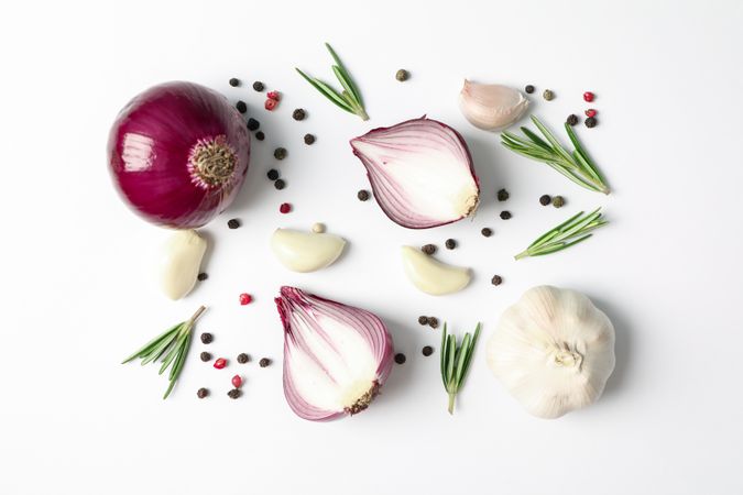 Flat lay composition with red onion and spices on plain background